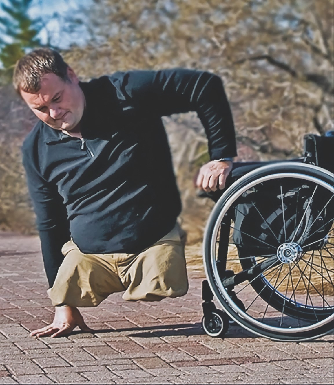 Matt Glowacki helps himself into his wheelchair from the ground.