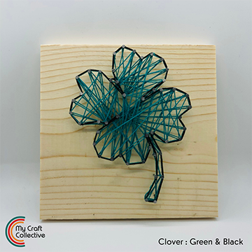 Clover string art made with green and black string.