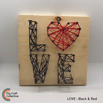 LOVE string art made with red and black string.