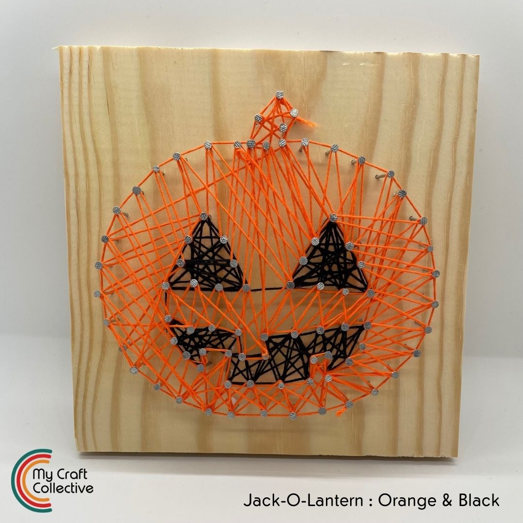 Jack-o-lantern string art made with orange and black string.