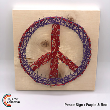 Peace sign string art made with red and purple string.