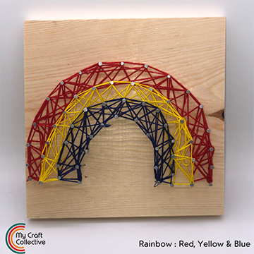 Rainbow string art made with red, yellow, and blue string.