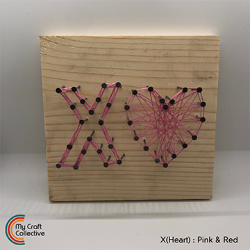 X(Heart) string art made with pink and red string.
