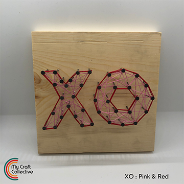 XO string art made with pink and red string.