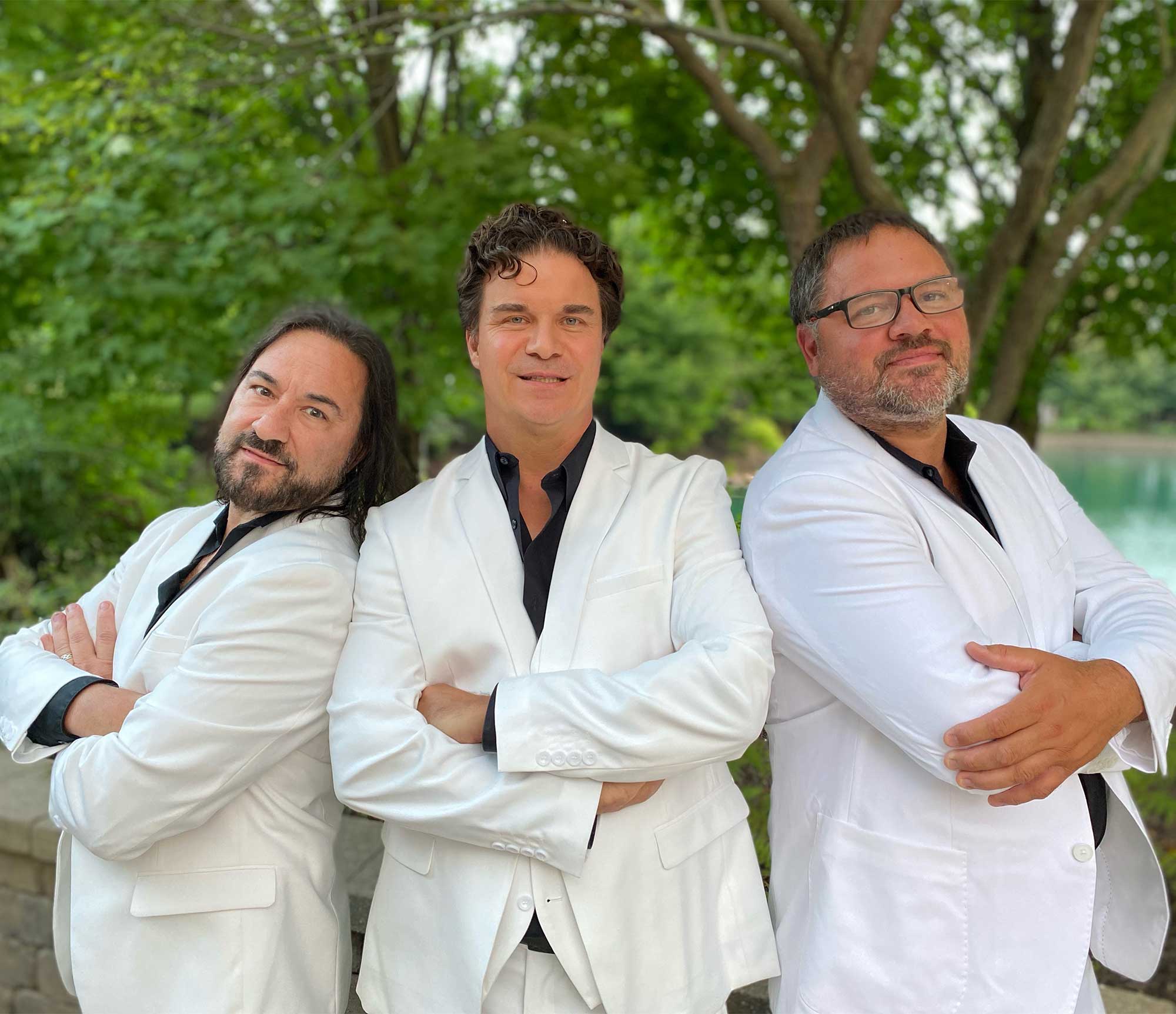 Brothers Gibb band members in white suits with black button downs underneath.